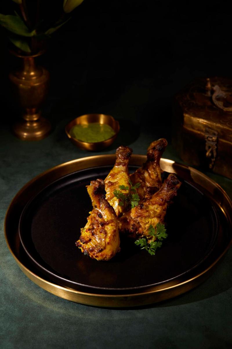 a plate of food with chicken on a table at JW Marriott Mumbai Juhu in Mumbai
