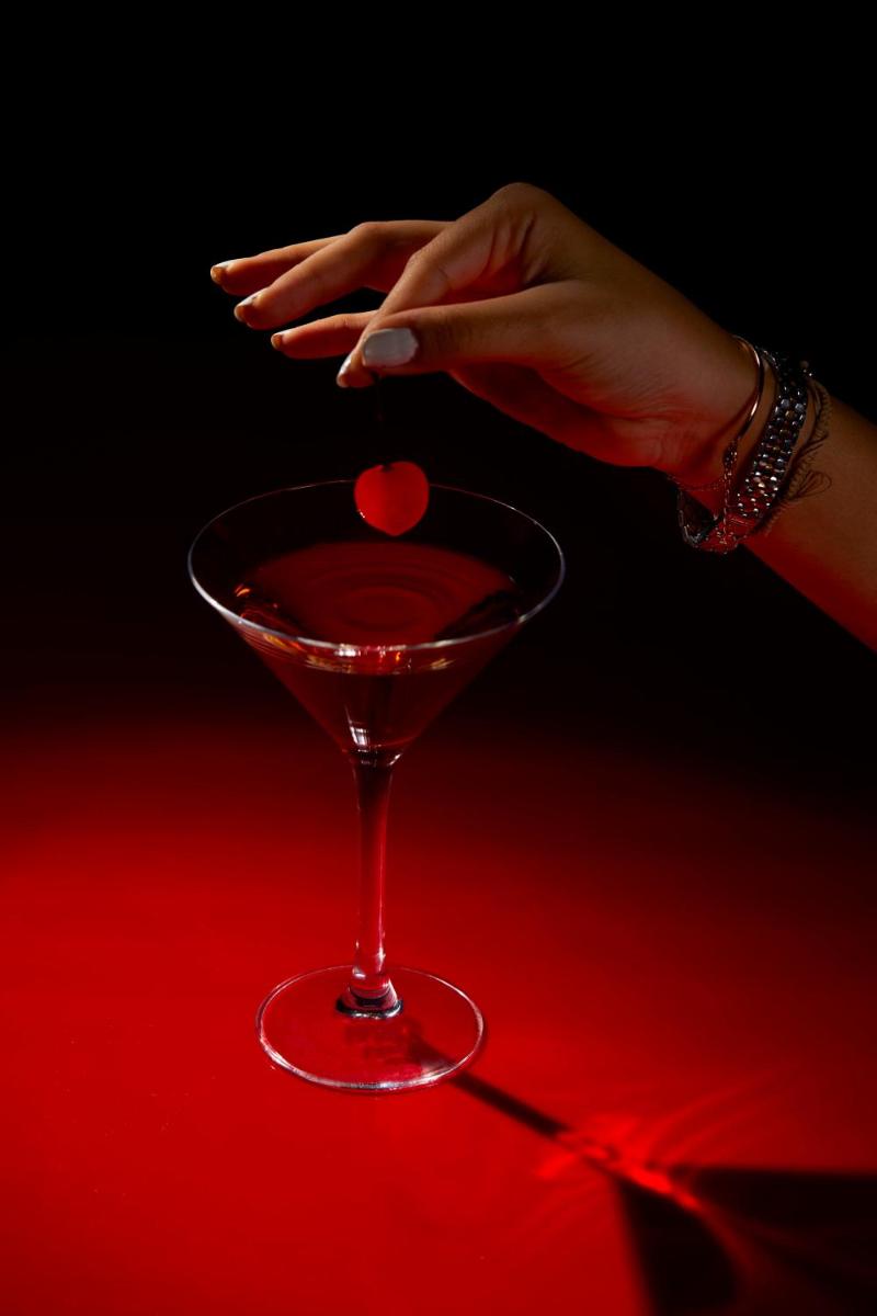a woman holding a red drink in a martini glass at JW Marriott Mumbai Juhu in Mumbai