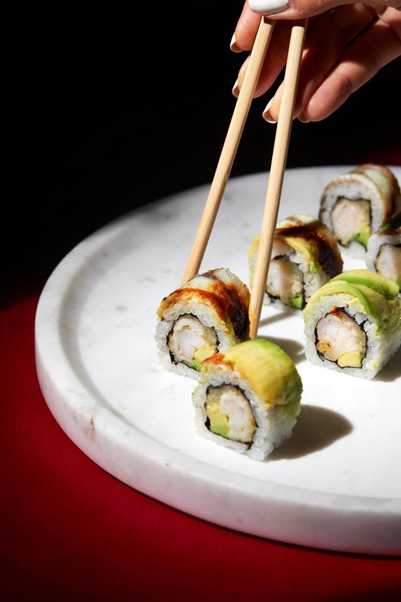 a plate of sushi with chopsticks on top of it at JW Marriott Mumbai Juhu in Mumbai