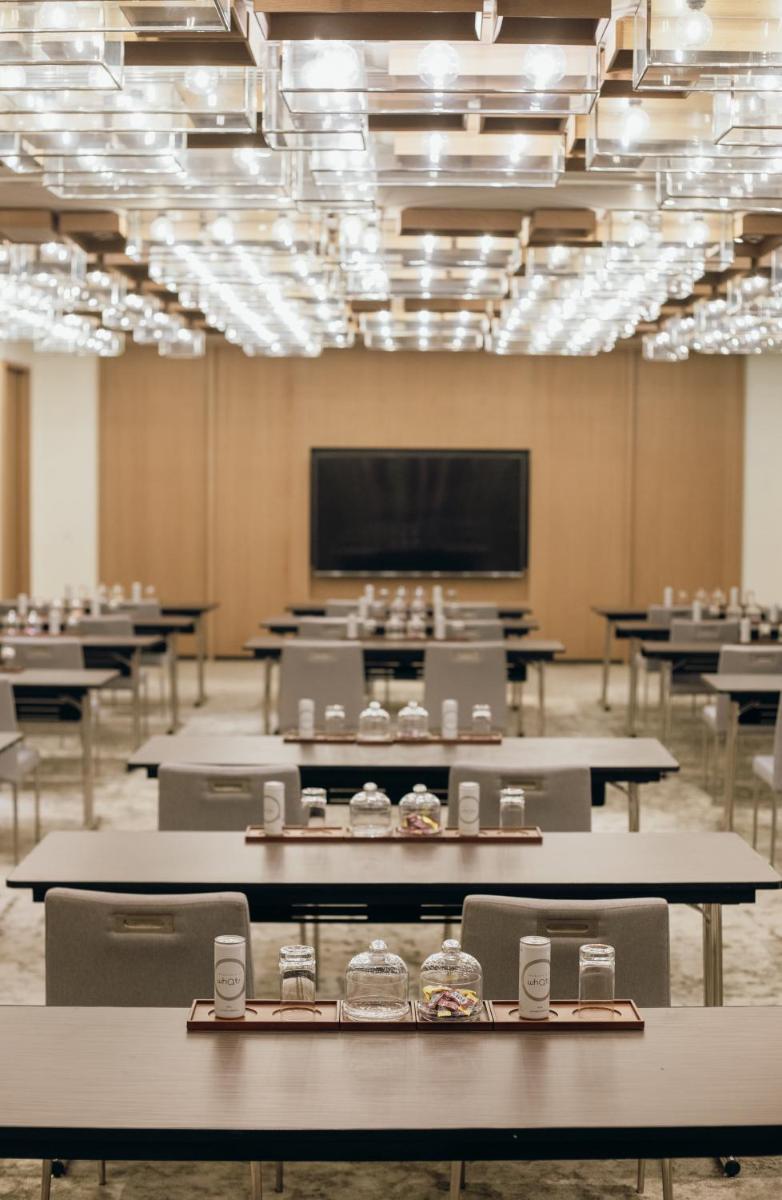 a room with tables and chairs and a projection screen at Grand Hyatt Gurgaon in Gurgaon