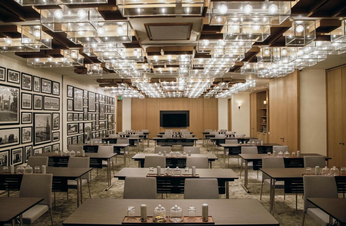 a large room with tables and chairs and a television at Grand Hyatt Gurgaon in Gurgaon