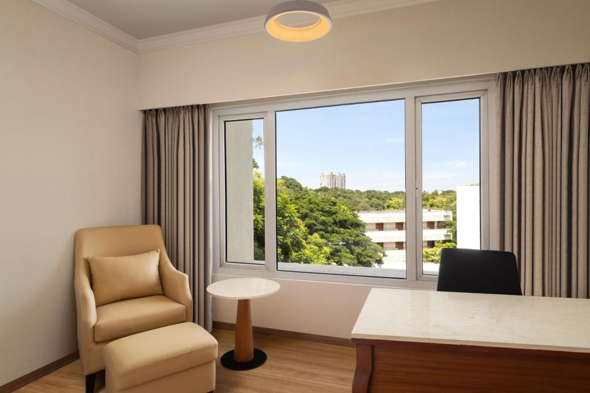 a room with a desk and a chair and a window at Courtyard by Marriott Tiruchirappalli in Tiruchchirāppalli