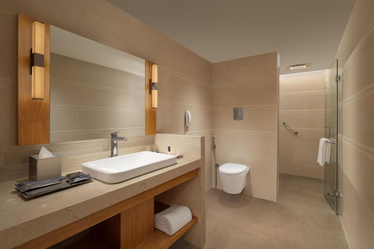 a bathroom with a sink and a toilet at Courtyard by Marriott Tiruchirappalli in Tiruchchirāppalli
