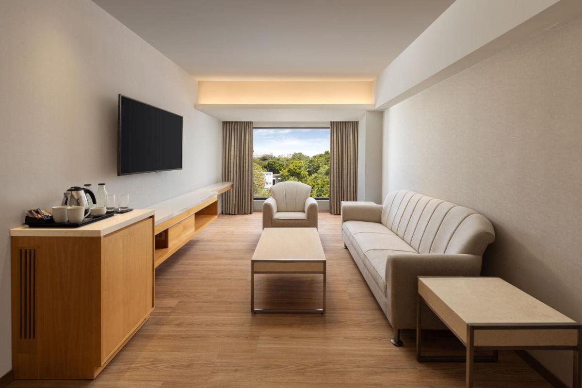 a living room with a couch and a tv at Courtyard by Marriott Tiruchirappalli in Tiruchchirāppalli