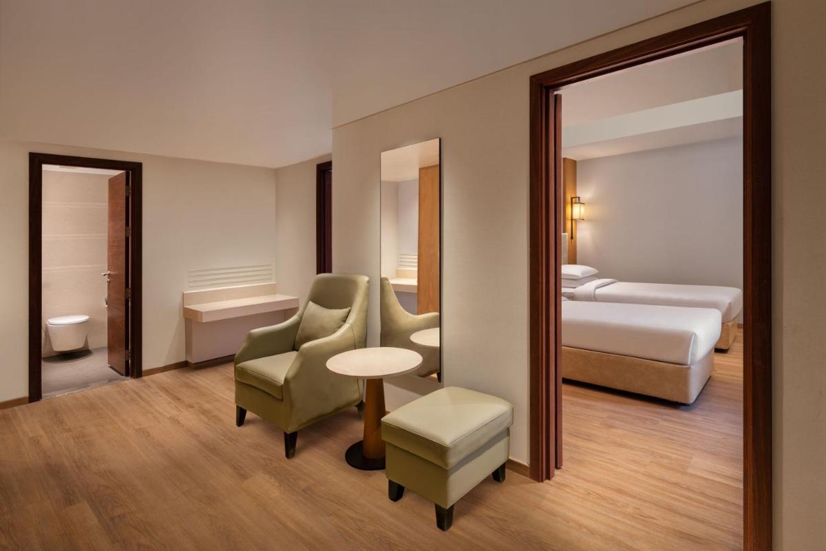 a hotel room with a bed and a mirror at Courtyard by Marriott Tiruchirappalli in Tiruchchirāppalli