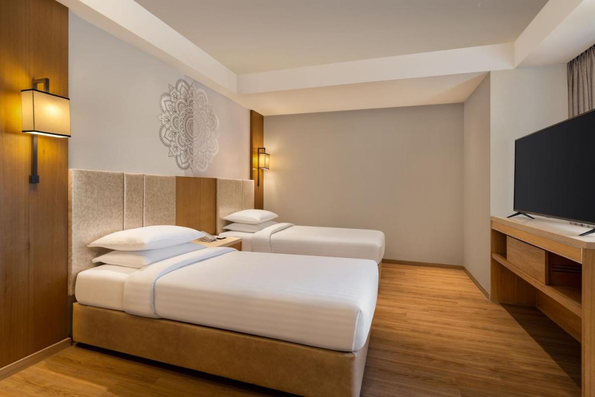 a hotel room with a bed and a flat screen tv at Courtyard by Marriott Tiruchirappalli in Tiruchchirāppalli