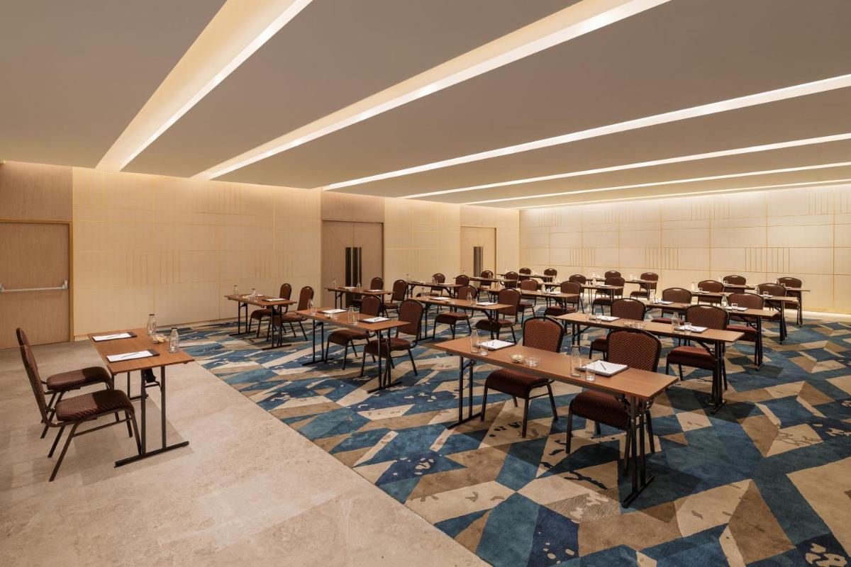 a classroom with tables and chairs in a room at Courtyard by Marriott Tiruchirappalli in Tiruchchirāppalli