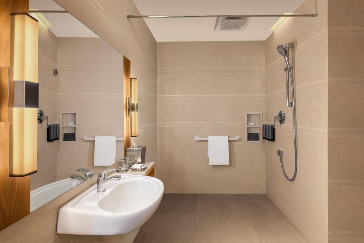 a bathroom with a sink and a shower at Courtyard by Marriott Tiruchirappalli in Tiruchchirāppalli