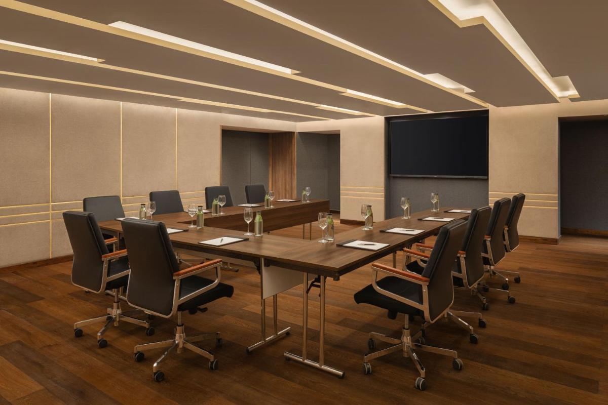 a conference room with a long table and chairs at Courtyard by Marriott Tiruchirappalli in Tiruchchirāppalli