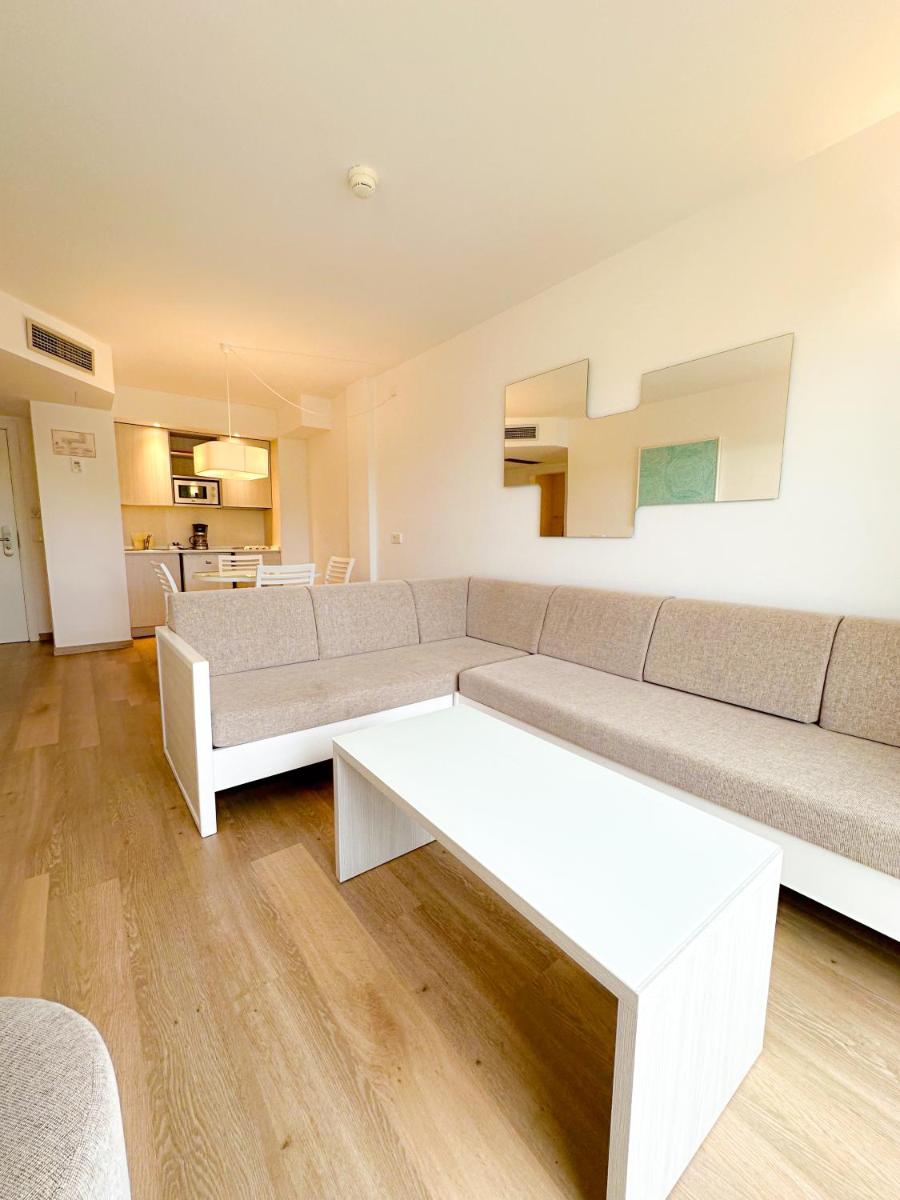 una sala de estar con un sofá y una mesa en Diamant Hotel & Aparthotel, en Cala Ratjada
