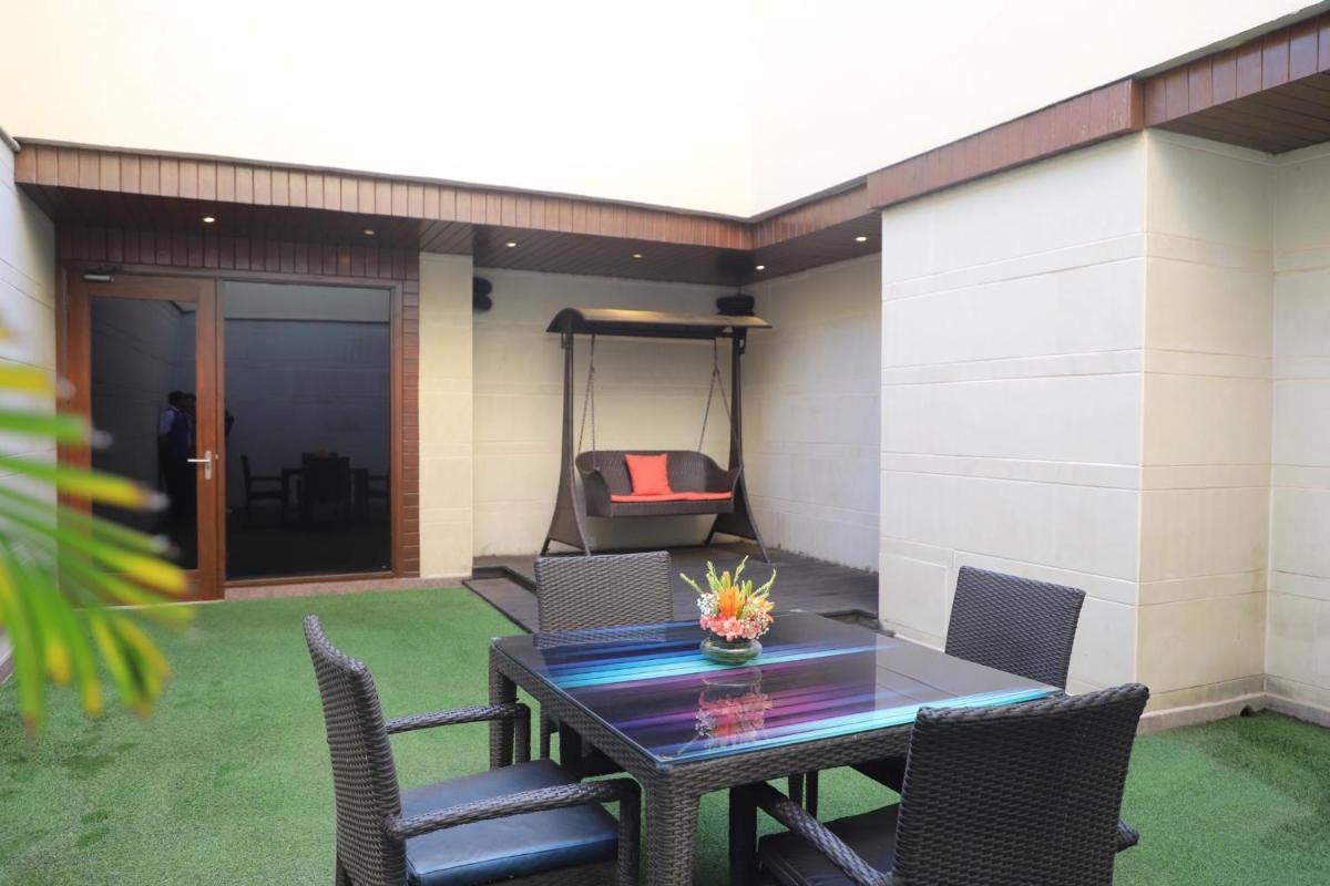 a patio with a table and chairs and a swing at DoubleTree by Hilton Gurgaon New Delhi NCR in Gurgaon
