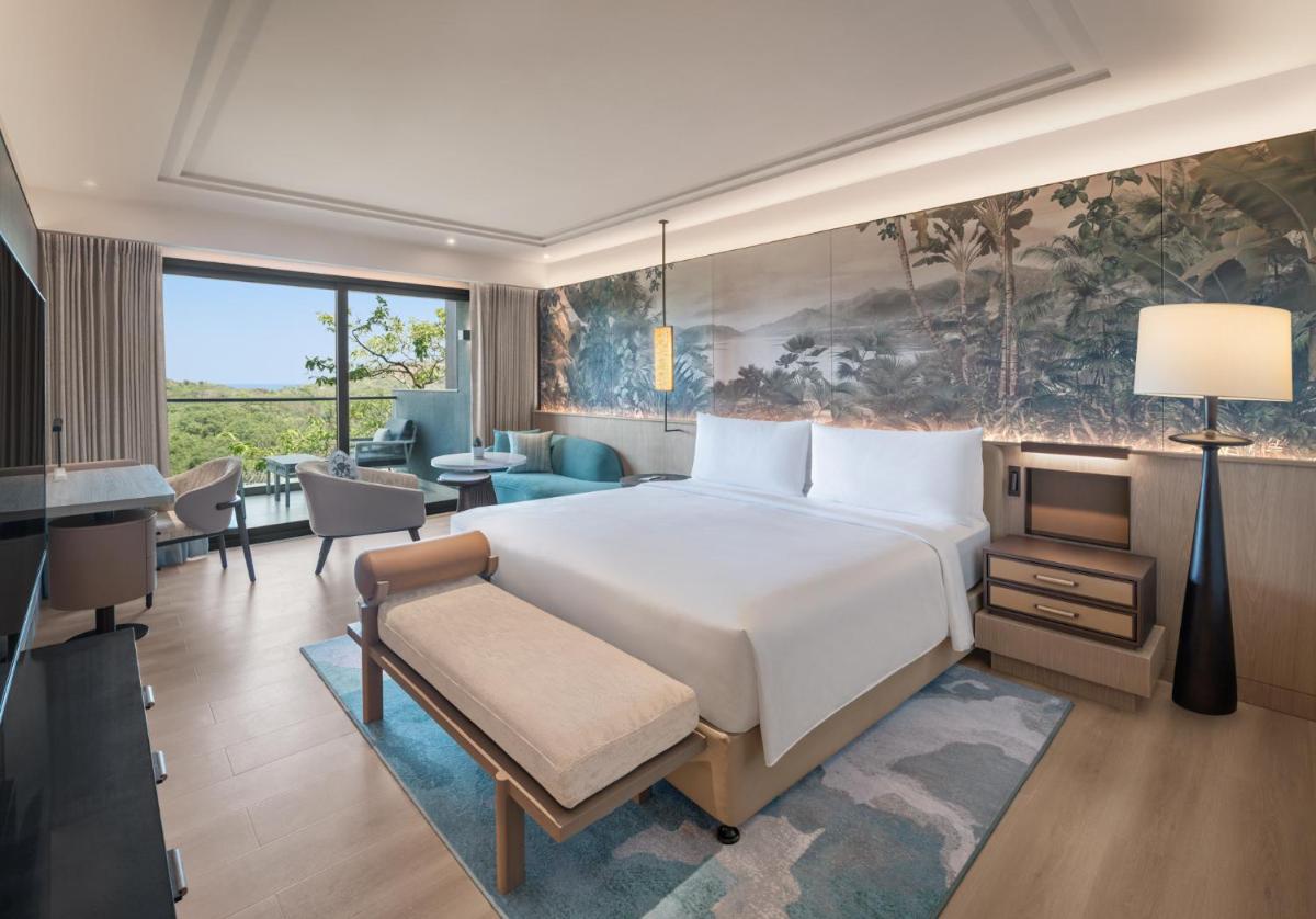 a bedroom with a large bed and a living room at JW Marriott Goa in Vagator a bedroom with a large bed and a living room at JW Marriott Goa in Vagator