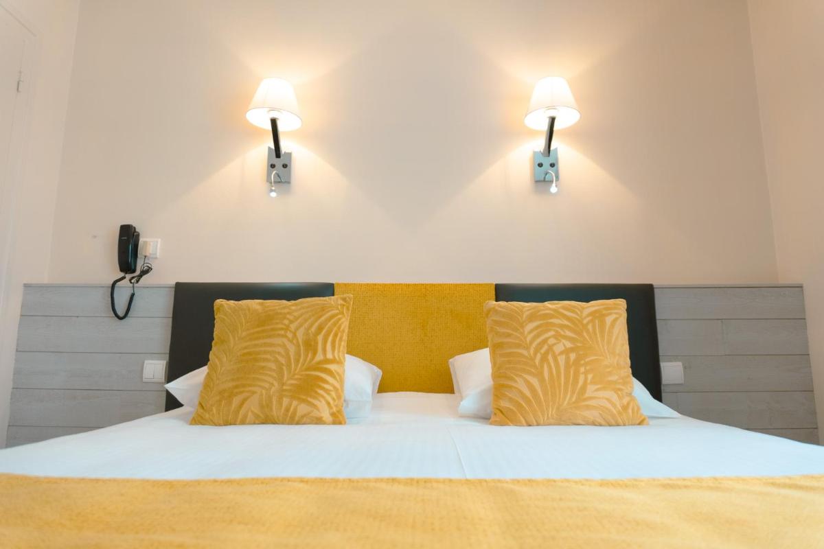 Un ou plusieurs lits dans un hébergement de l'établissement Hôtel Spa & Restaurant Ô Pervenches
