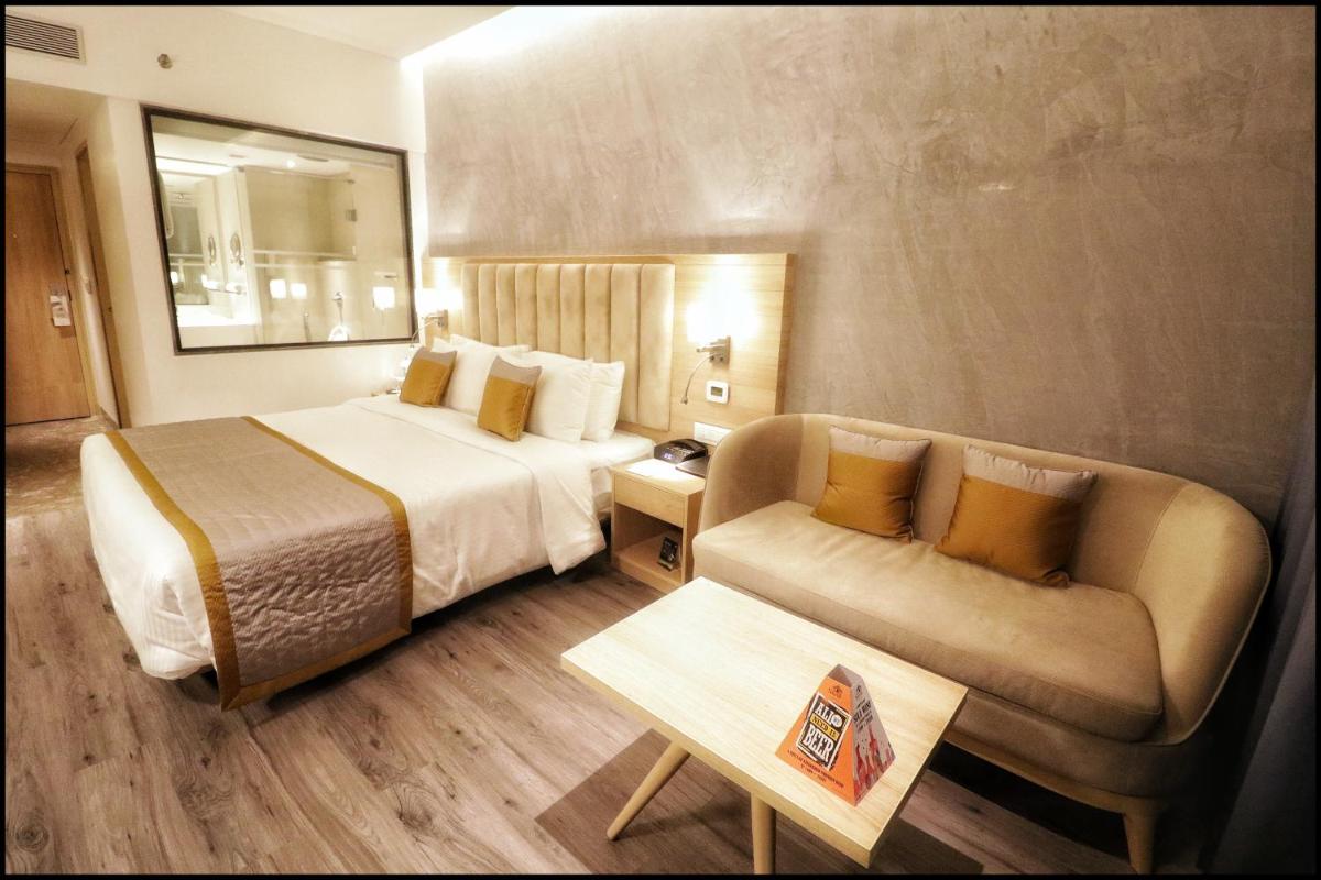 a hotel room with a bed and a couch at Sayaji Pune in Pune