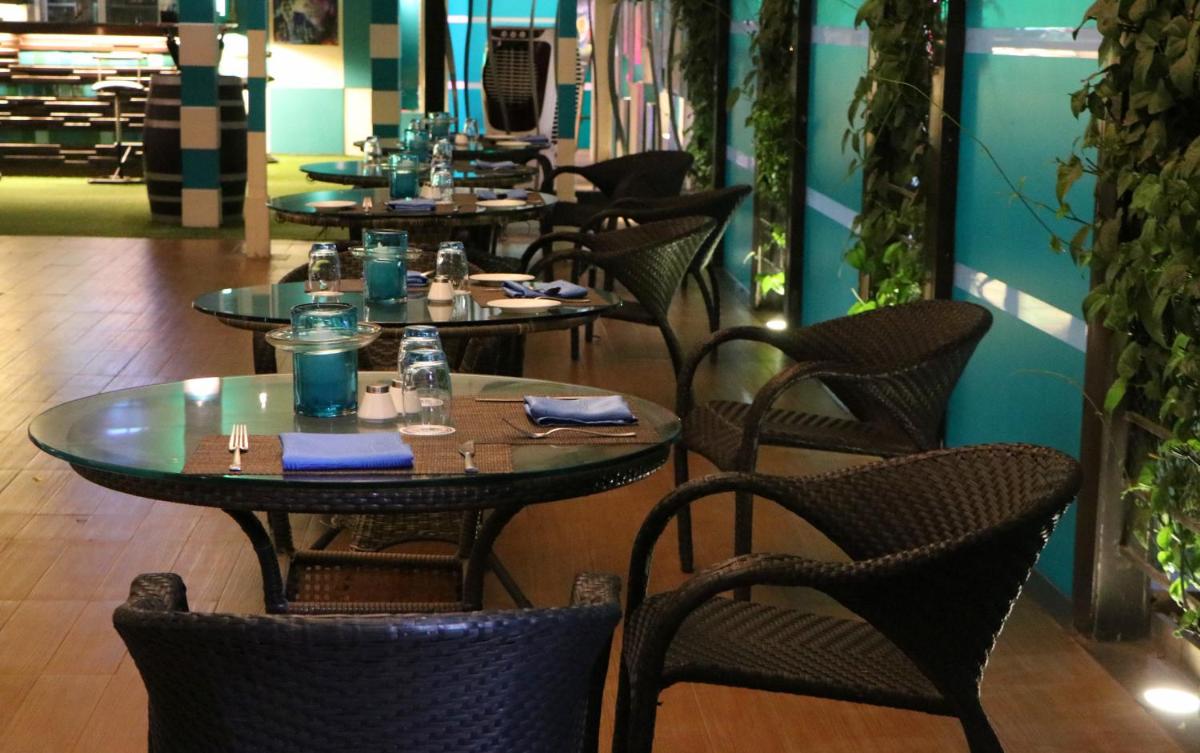 a row of tables and chairs in a restaurant at Sayaji Pune in Pune