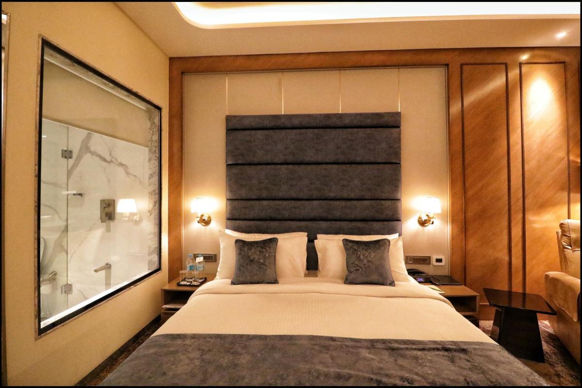 a bedroom with a large bed with two pillows at Sayaji Pune in Pune