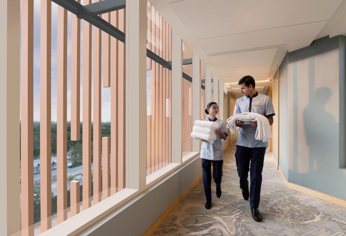a man and a woman walking down a hallway at InterContinental Jaipur Tonk Road by IHG in Jaipur