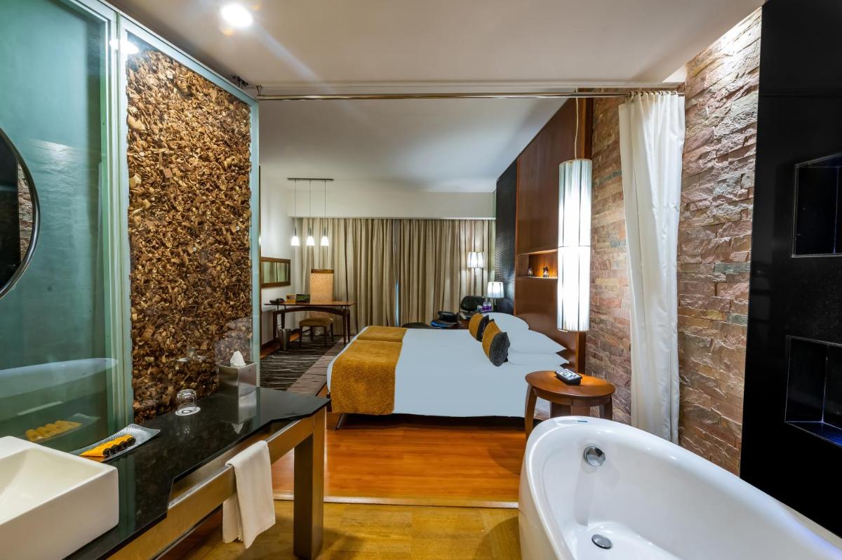 a hotel room with a bed and a bath tub at O Hotel Pune in Pune