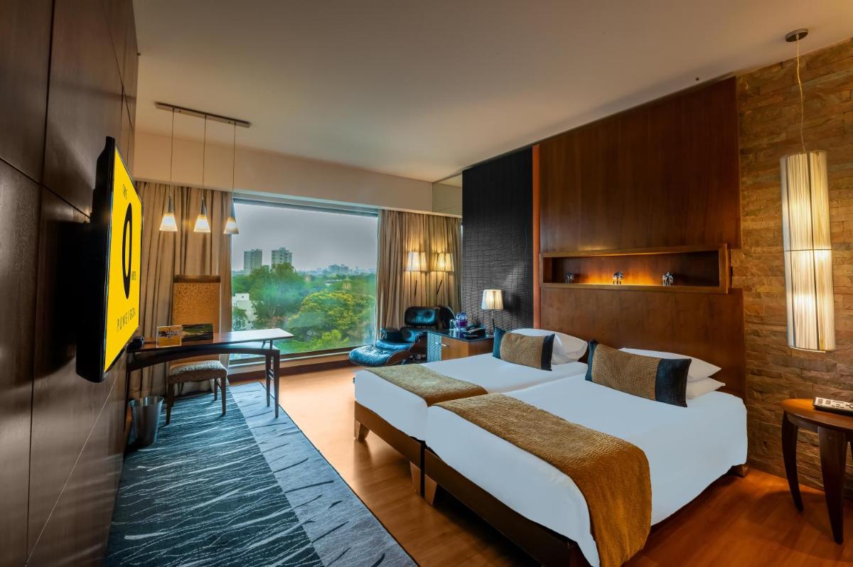 a hotel room with a bed and a desk at O Hotel Pune in Pune
