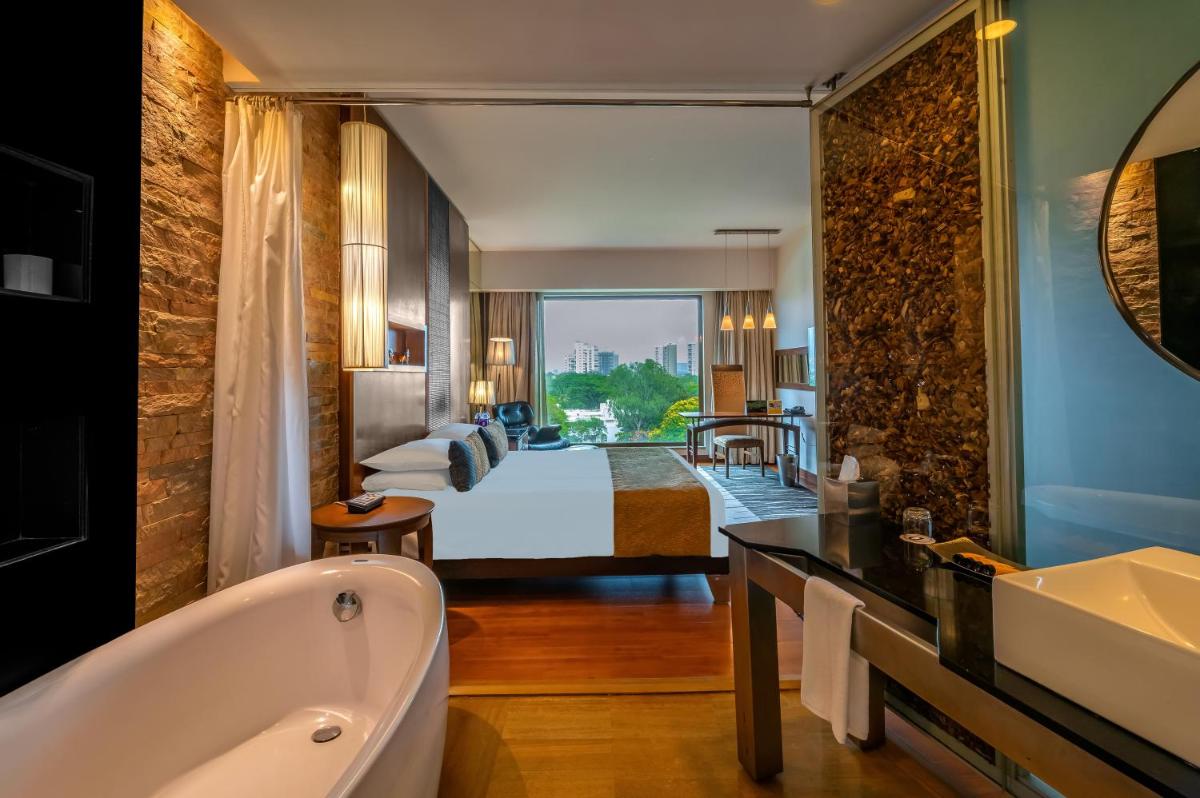 a hotel room with a bed and a bath tub at O Hotel Pune in Pune