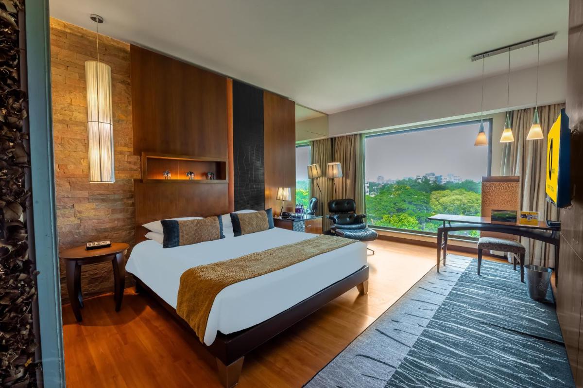 a hotel room with a bed and a desk at O Hotel Pune in Pune