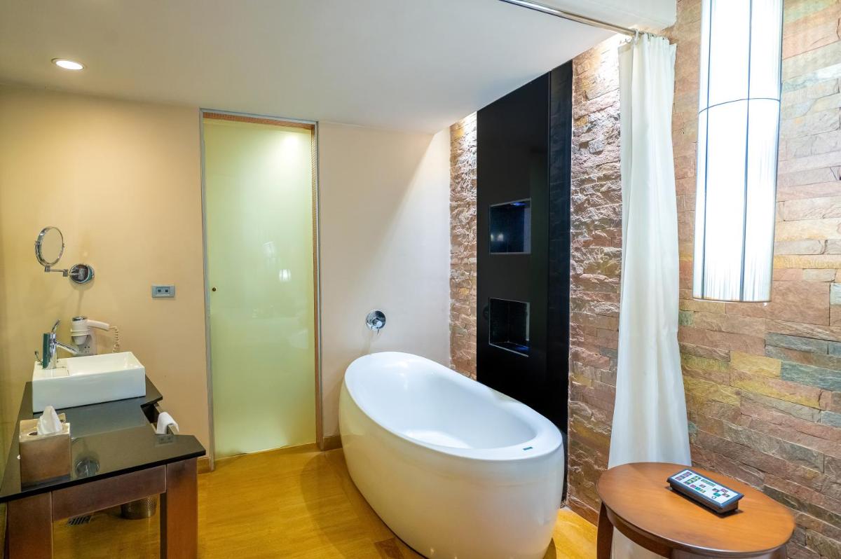 a bathroom with a white tub and a sink at O Hotel Pune in Pune