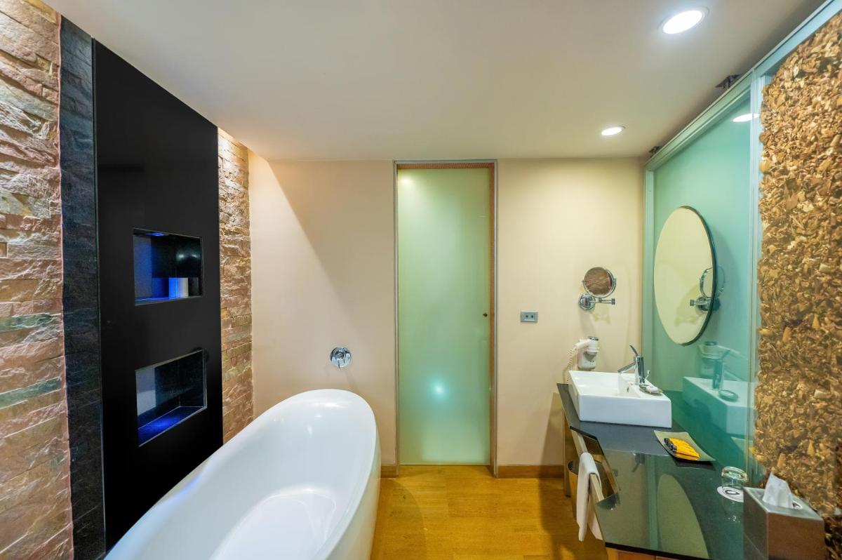 a bathroom with a tub and a sink at O Hotel Pune in Pune