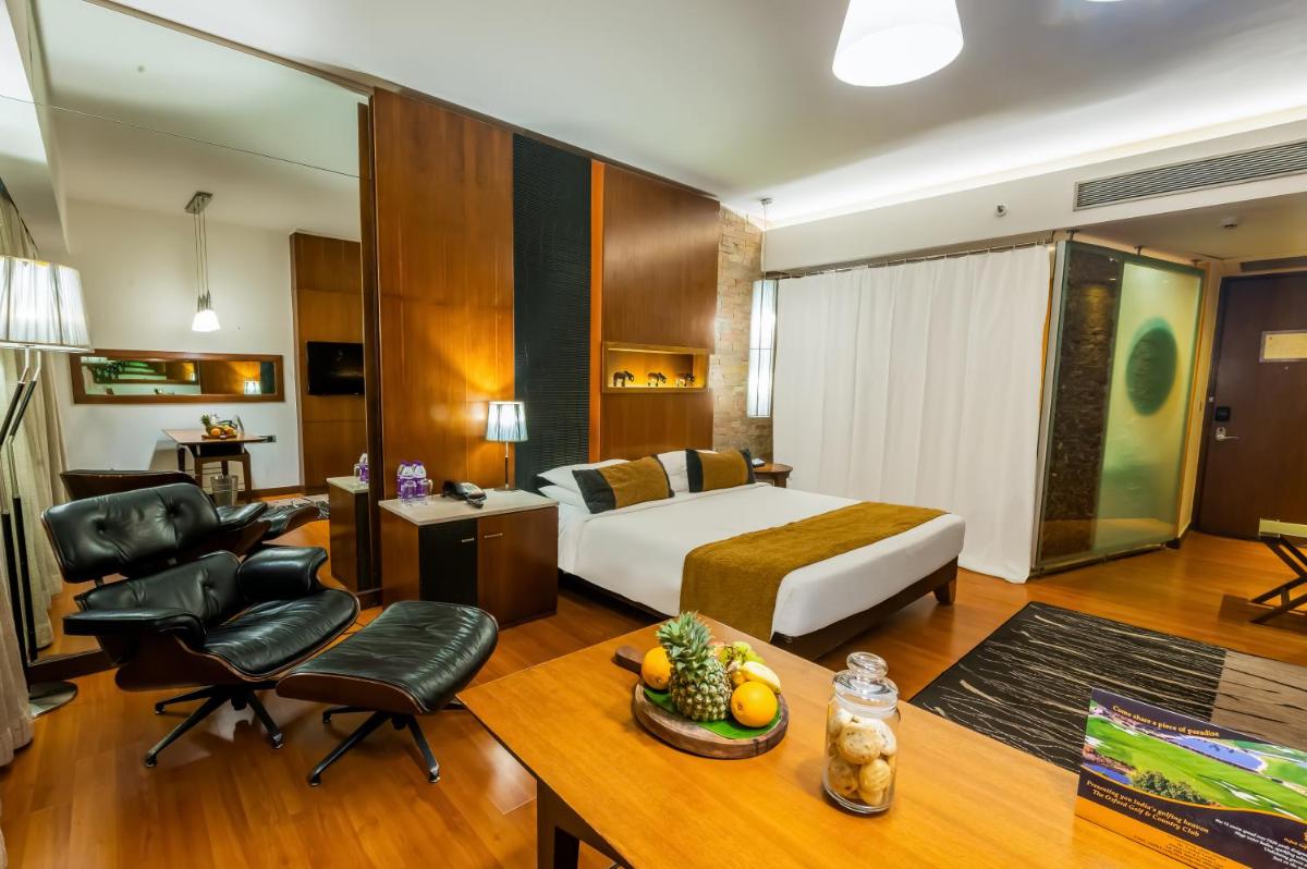 a hotel room with a bed and a desk and chair at O Hotel Pune in Pune