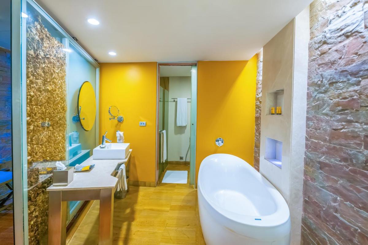 a bathroom with a tub and a sink at O Hotel Pune in Pune