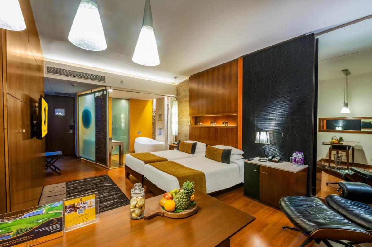 a bedroom with a bed and a living room at O Hotel Pune in Pune