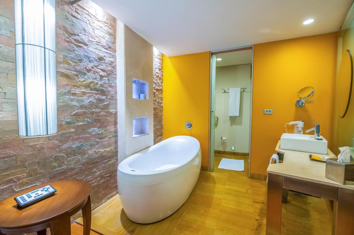 a bathroom with a white tub and a sink at O Hotel Pune in Pune