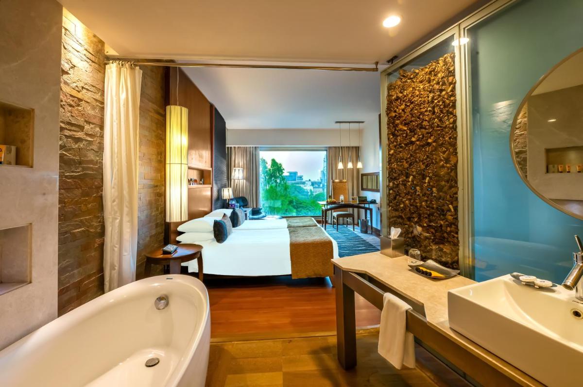 a hotel room with a bed and a tub and a bathroom at O Hotel Pune in Pune