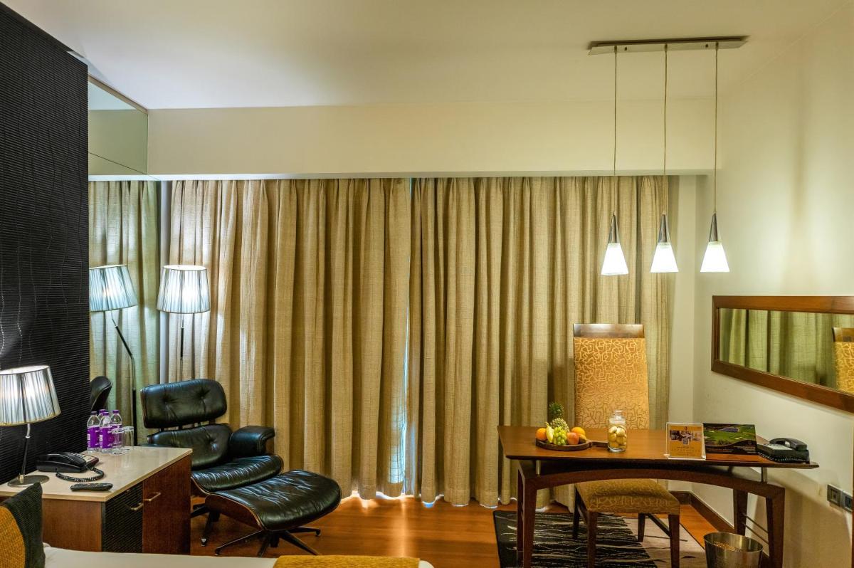 a living room with a table and chairs in a room at O Hotel Pune in Pune