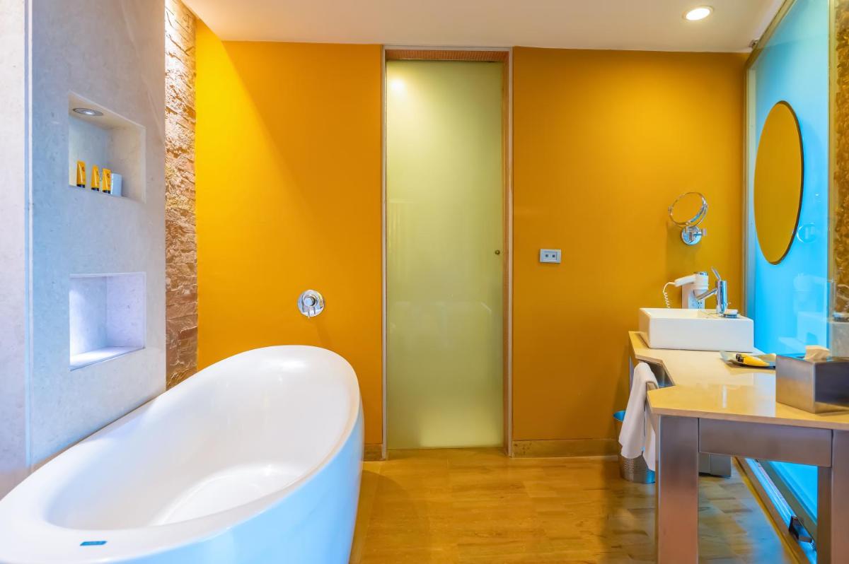 a bathroom with a tub and a sink at O Hotel Pune in Pune