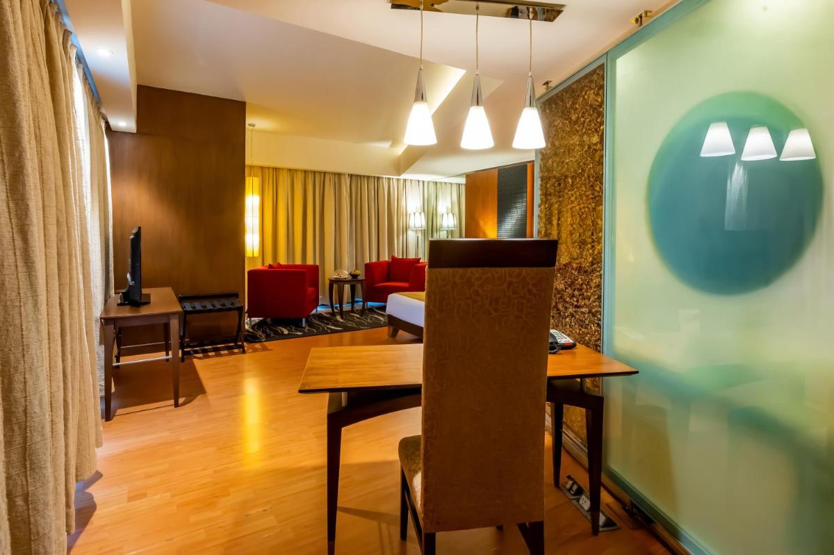 a dining room with a table and chairs in a room at O Hotel Pune in Pune