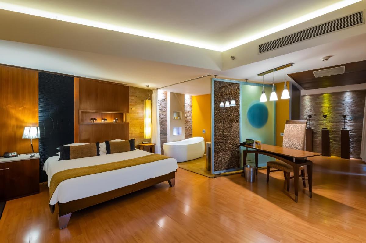 a bedroom with a bed and a desk and a table at O Hotel Pune in Pune