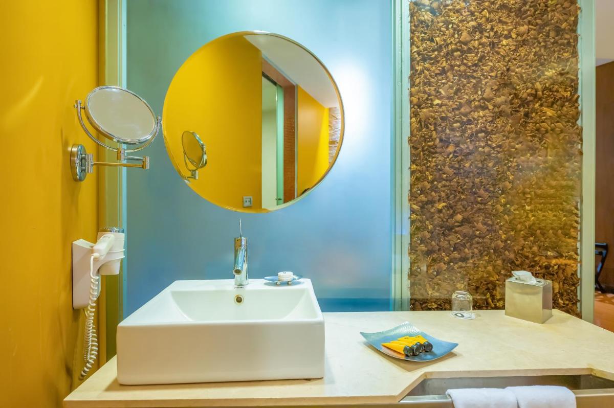a bathroom with a white sink and a mirror at O Hotel Pune in Pune