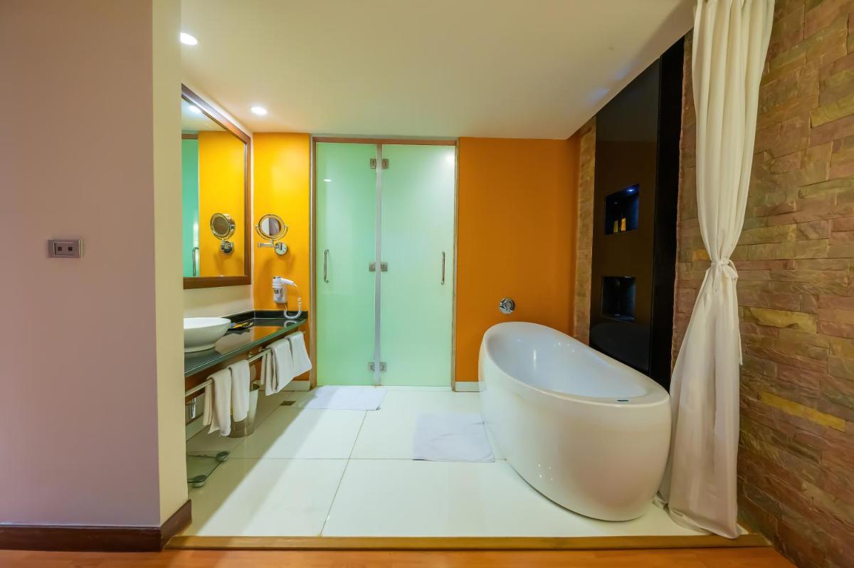 a bathroom with a tub and a sink at O Hotel Pune in Pune