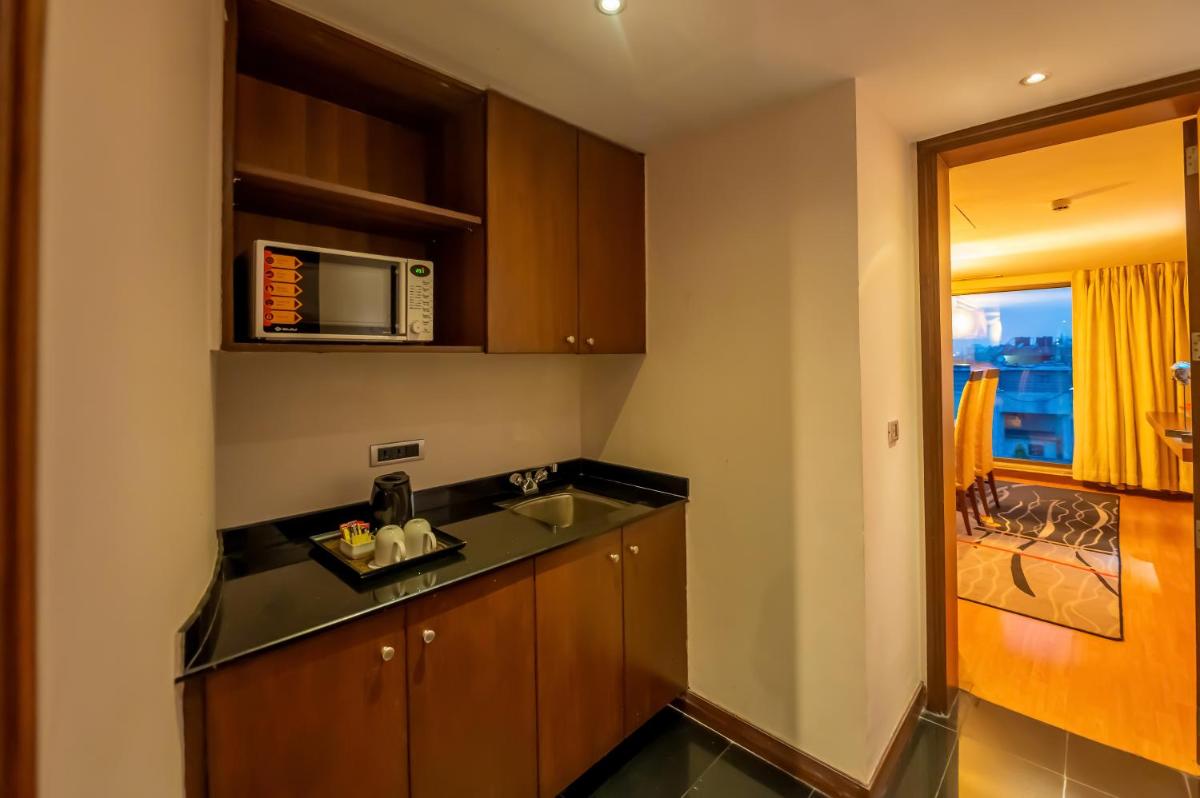 a kitchen with a sink and a microwave at O Hotel Pune in Pune