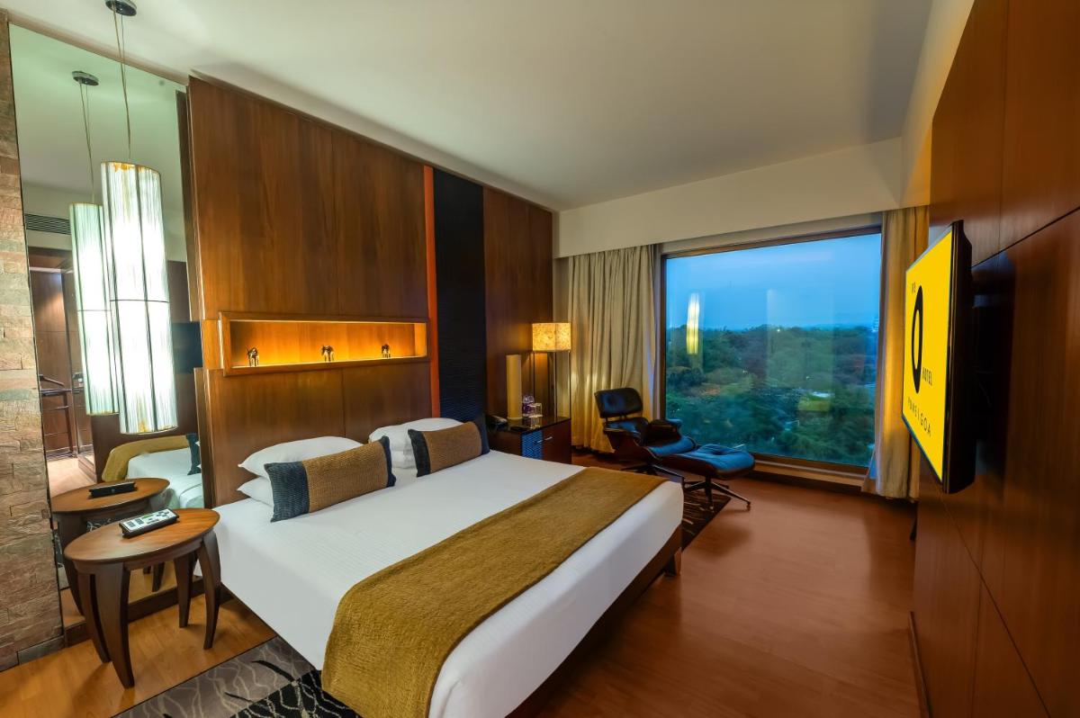 a hotel room with a large bed and a large window at O Hotel Pune in Pune