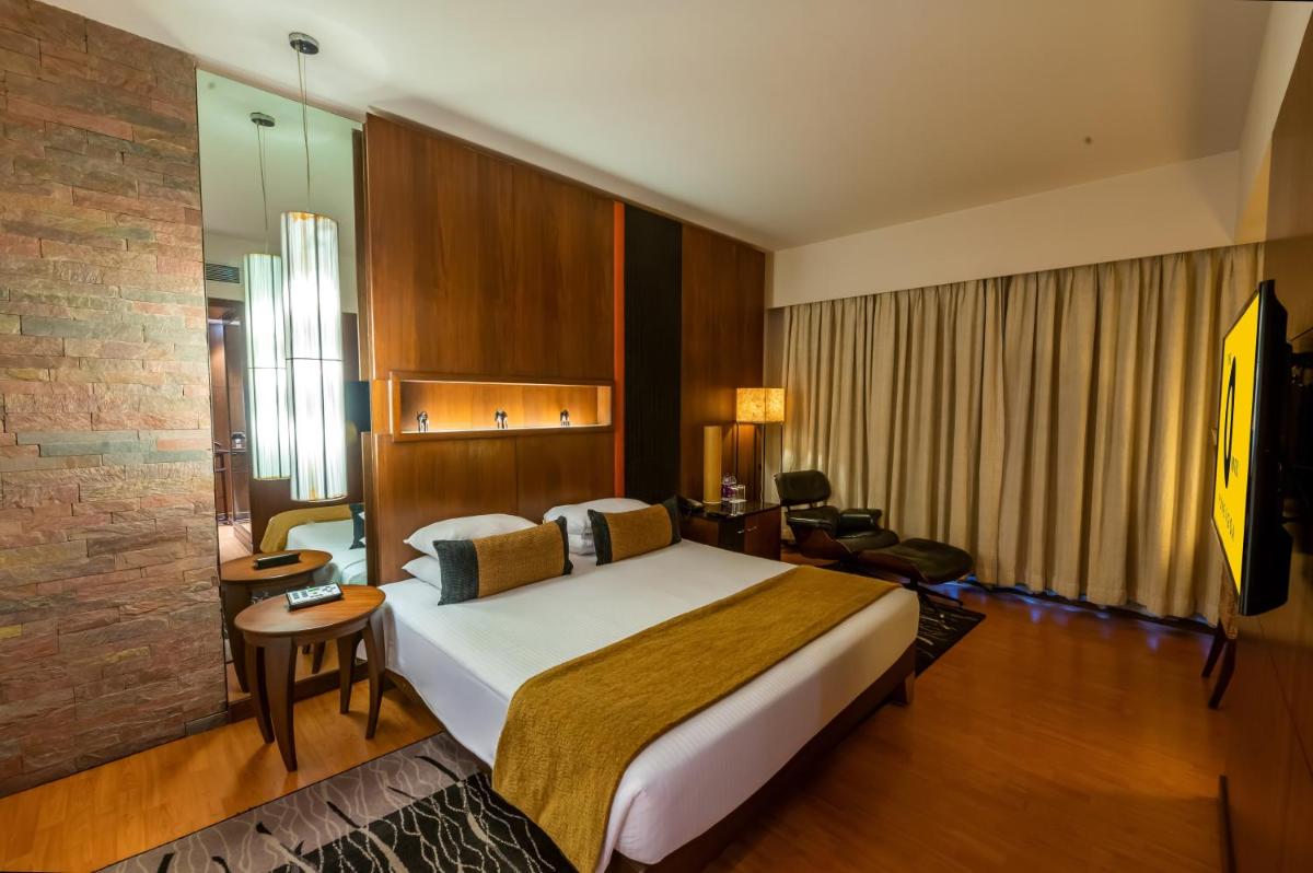 a bedroom with a large bed in a hotel room at O Hotel Pune in Pune