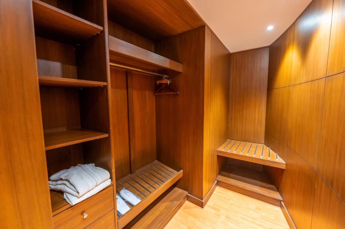a walk in closet with wooden walls and shelves at O Hotel Pune in Pune