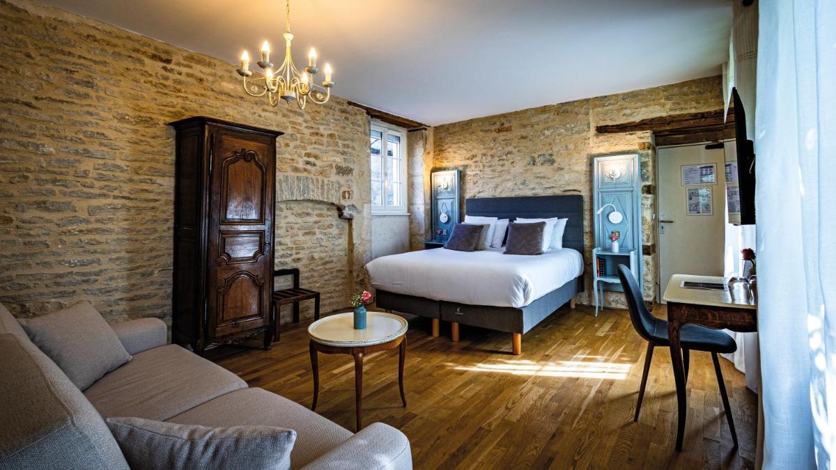 une chambre avec un lit et un canapé dans une pièce dans l'établissement Logis Relais de la Source, à Saint-Seine-lʼAbbaye
