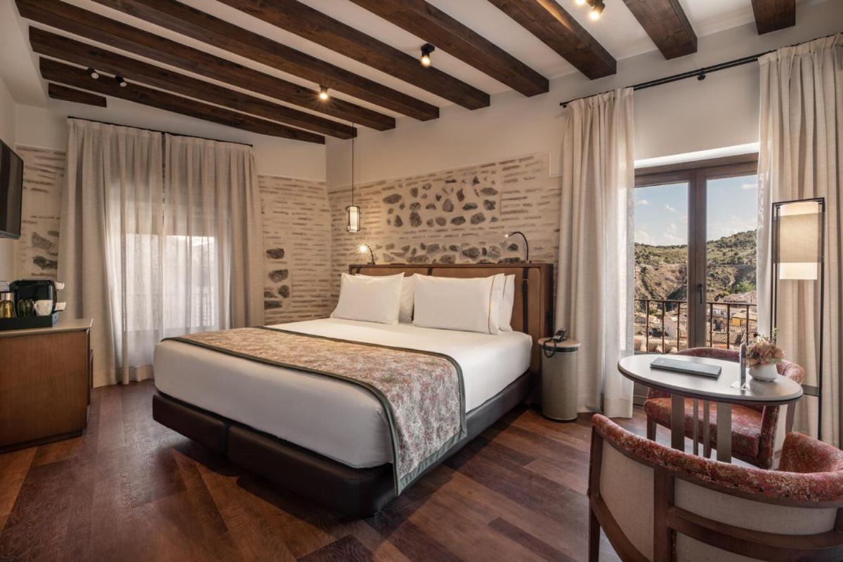 Un dormitorio con una cama y una mesa y una ventana. en Áurea Toledo by Eurostars Hotel company, en Toledo
