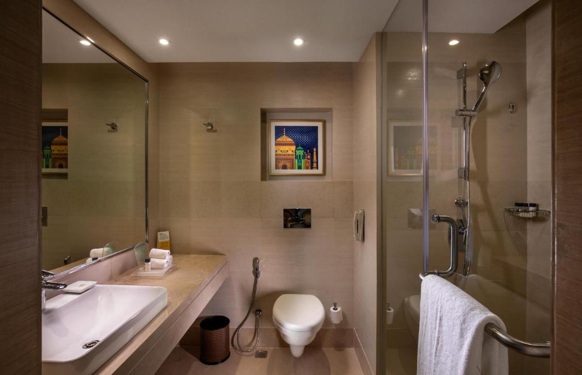a bathroom with a toilet and a sink and a shower at Holiday Inn Agra MG Road an IHG Hotel in Agra
