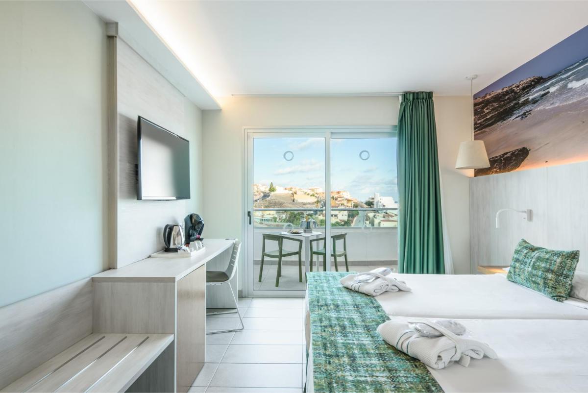 una habitación de hotel con una cama y un balcón en FERGUS Cactus Garden, en Playa de Jandía 24 fotos más