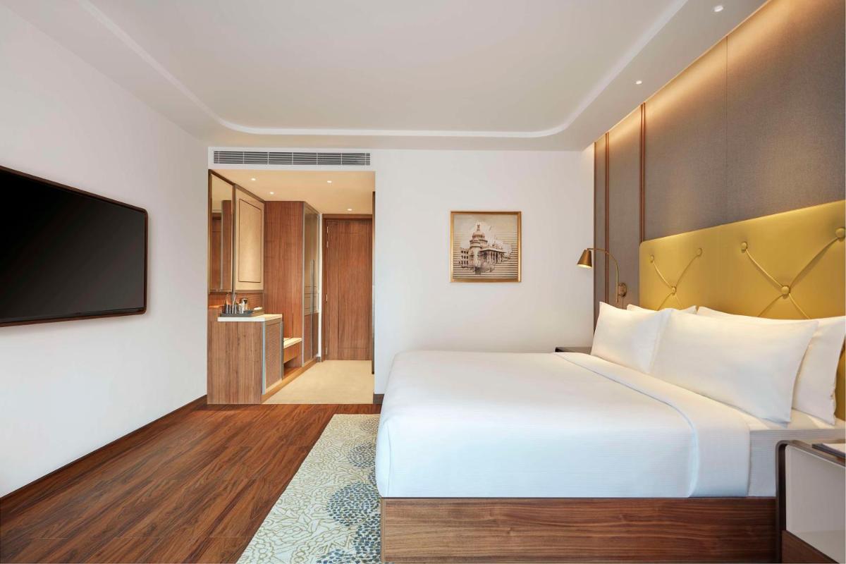 a hotel room with a large bed and a television at Doubletree By Hilton Bengaluru Whitefield in Bengaluru
