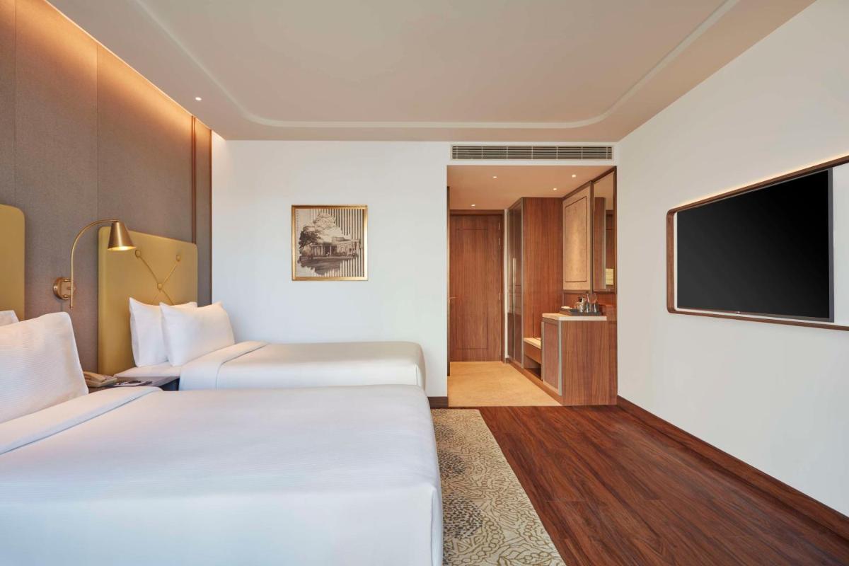 a hotel room with two beds and a flat screen tv at Doubletree By Hilton Bengaluru Whitefield in Bengaluru
