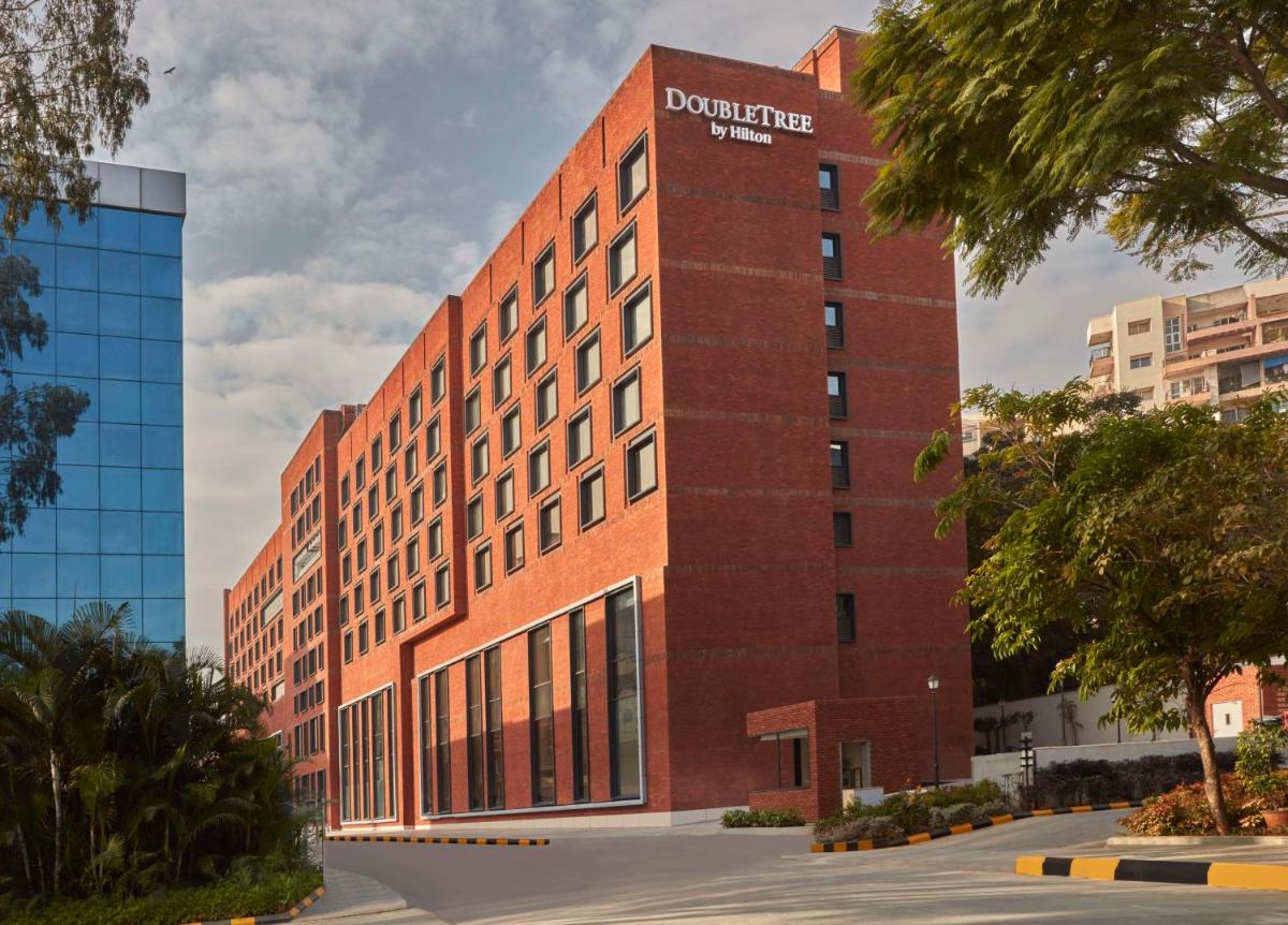 a red brick building with a sign on it at Doubletree By Hilton Bengaluru Whitefield in Bengaluru