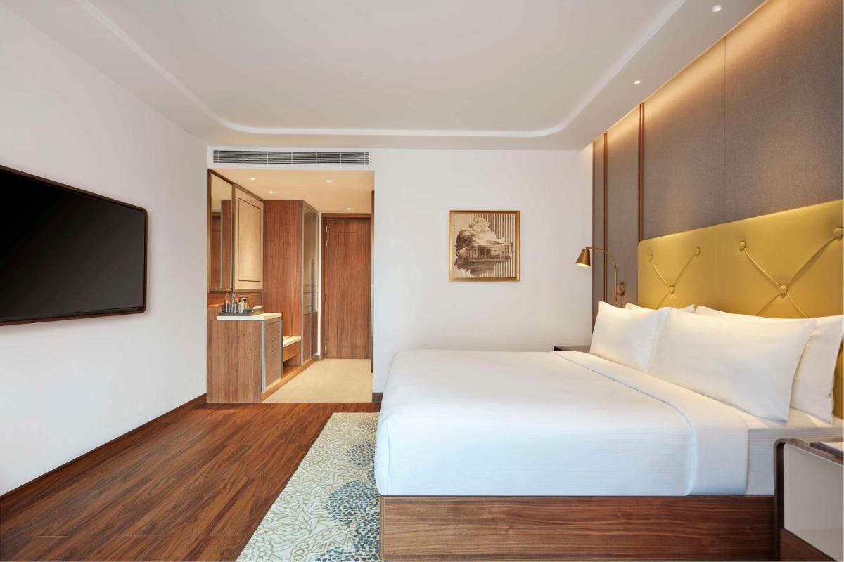 a hotel room with a large bed and a television at Doubletree By Hilton Bengaluru Whitefield in Bengaluru